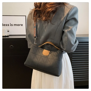 Detail of grey PU leather tote with geometric stitching and ethnic print strap