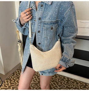 Detail of hand-woven cream hobo bag showing natural texture and stylish white shoulder strap