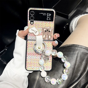 Detail of tweed phone case for Z Flip with rhinestones, heart charm and bead strap