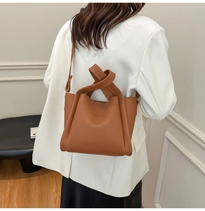 Detail of a brown lychee pattern bucket bag featuring a unique knotted handle design