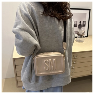 Chic cream crossbody bag with embossed SM letters and striped wide shoulder strap