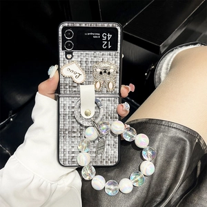 Chic grey woven phone case detail with pearl wrist strap and rhinestone rabbit charm