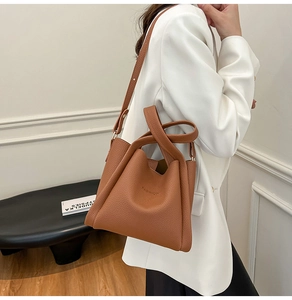 Close-up of brown lychee pattern leather bucket bag with FASHION embossed detail