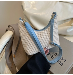 Detail of sky blue leather trim and woven texture on a semi-circle beach tote bag