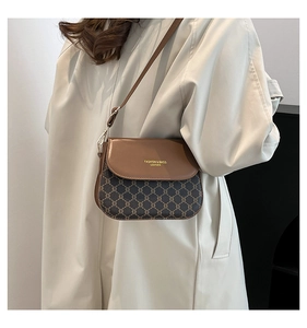 Détail du sac besace vintage avec motif monogramme rétro et lettrage doré en relief