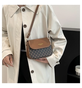 Détail du sac bandoulière vintage avec rabat en cuir marron et lettrage doré