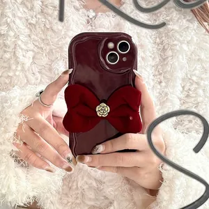 Detail of red velvet bow and golden camellia flower on wavy iPhone phone case