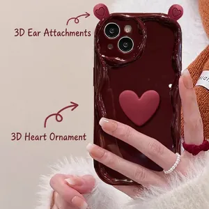 Close-up of 3D bear ears and heart charms on a brown silicone iPhone case