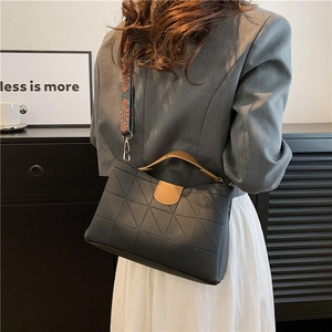 Detail of dark grey quilted PU leather tote with ethnic print wide shoulder strap
