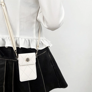 Bolso bandolera acolchado para móvil con broche de rosa mostrado en una modelo