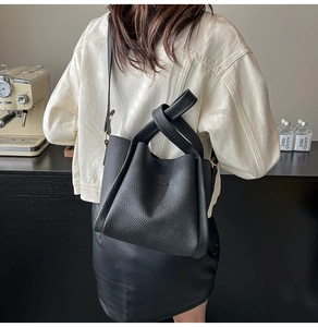 Detailed texture of black lychee grain leather bucket bag with knot handle detail