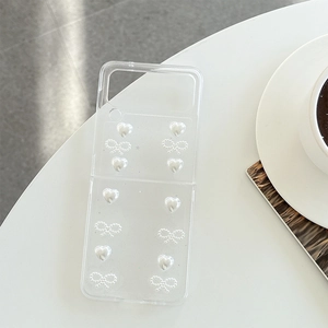 Détail de la coque transparente Z Flip avec cœur en perle 3D et nœud perlé élégant