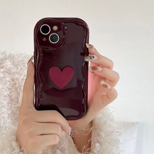 Detail of burgundy wavy iPhone case featuring a 3D heart ornament and glossy finish
