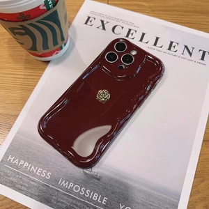 Macro detail of wine red wavy edge iPhone case featuring a golden metallic rose decoration