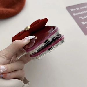 Detail of precise cutouts on wine red silicone phone case with large fabric bow