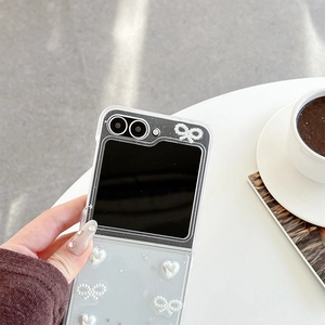 Détail de la coque transparente avec nœud en perles et cœurs pour téléphone pliant