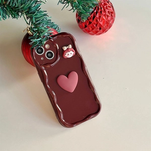 Close-up of wine red wavy phone case with 3D pink heart and cute girl charm in holiday setting