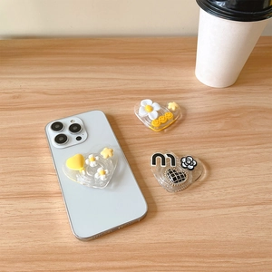 Détail de supports téléphone en cœur transparents avec fleurs et motif de lettre M