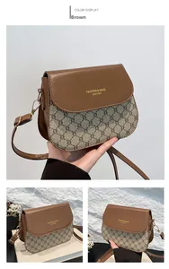 Détail du sac de selle en cuir marron avec motif monogramme et boucle dorée