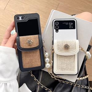 Detail of luxury tweed and leather phone case with rose buckle and pearl crossbody chain