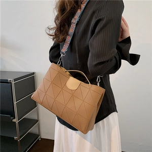 Brown leather tote with geometric stitching and a vintage ethnic patterned wide strap