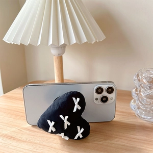 3D heart shaped phone socket with bow stitch on blue smartphone on wooden desk