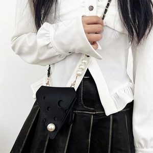 Detail of cheese-shaped phone case with large pearl and elegant gold chain strap