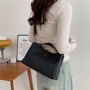 Detailed view of black PU tote bag with geometric texture and colorful woven strap