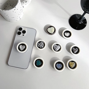 Various heart-shaped pop sockets with checkered and glitter patterns on white background