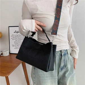 Detail of black geometric PU leather handbag with colorful ethnic style wide strap