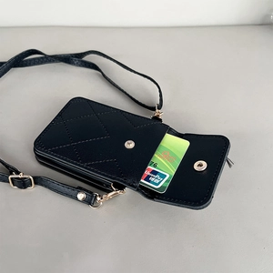 Detalle de billetera de cuero acolchado negro con ranuras para tarjetas y correa oro