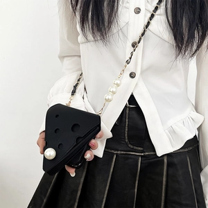 Detail of cheese-shaped triangular crossbody bag with large pearl strap decoration
