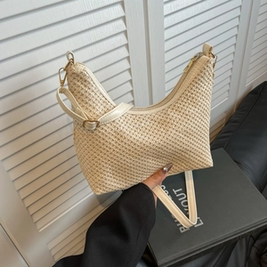 Stylish beige woven straw tote bag with adjustable leather strap for beach travel