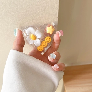 Gros plan du support cœur à paillettes avec petites marguerites et smileys jaunes