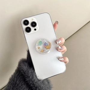 Detail of transparent star planet phone grip with glitter and resin finish on smartphone