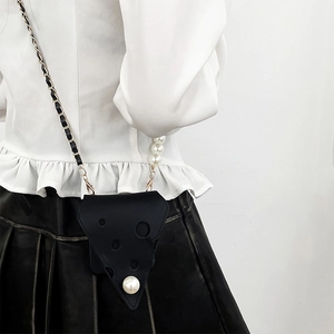 Detail of black cheese-shaped triangle bag with large pearl and chain crossbody strap