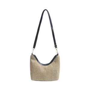 Fashionable woven straw tote bag for women featuring black faux leather straps and gold buckles