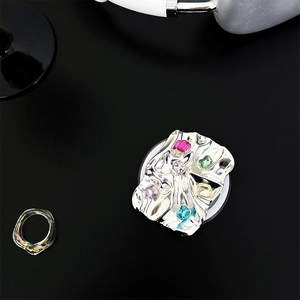 Detail of silver plated square phone socket with colorful gemstones and wrinkled metal texture