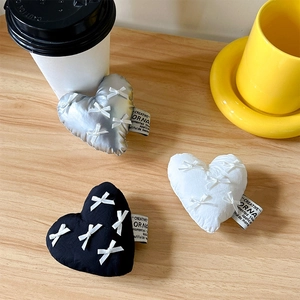 Detailed view of plush heart phone grips with bows in silver, white and black colors