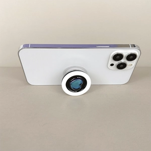 Close-up of a white collapsible phone socket with a blue gradient heart on a smartphone