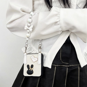 Off-white Samsung Z Flip 5 case with pearl strap, bow detail, and cute rabbit charm