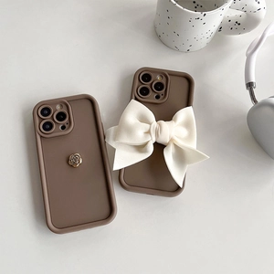 Coque iPhone marron en silicone avec rose dorée et nœud blanc, élégante et chic