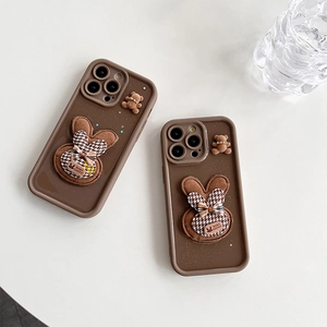 Dettaglio di cover iPhone marroni glitterate con coniglietti 3D e decoro orsetto