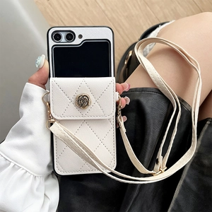 Detalle de funda de cuero blanco acolchado con hebilla de rosa dorada y correa larga