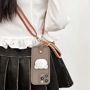 Detail of iPhone case with 3D bear stand, brown leather crossbody strap and woven wristlet