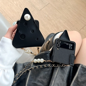 Detail of cheese-shaped black Z Flip case with large pearl accents and chain strap