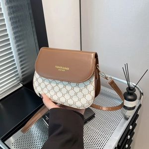 Sacoche vintage en cuir marron avec motif monogramme beige et bandoulière réglable