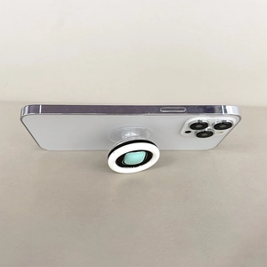 Foldable mint green pop socket stand showing extension detail on a white smartphone
