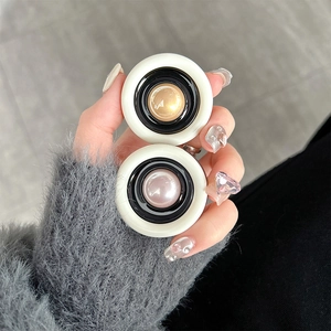 Detail of multi-layered round phone socket with cream ring and pearl finish center