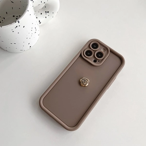 Gros plan sur la coque iPhone en silicone marron moka avec un ornement de rose dorée 3D